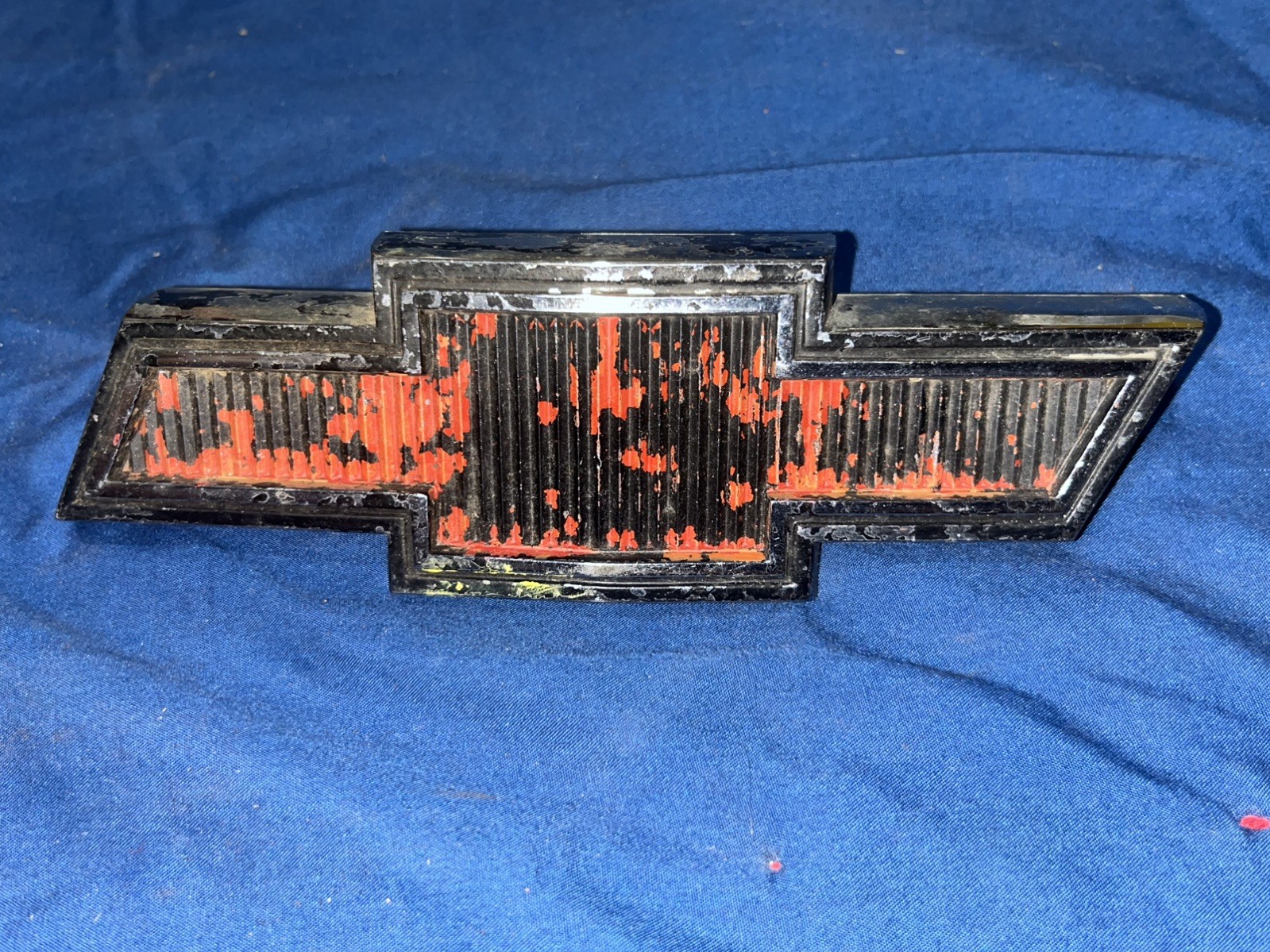 Original used red Chevy bowtie grill emblem. 